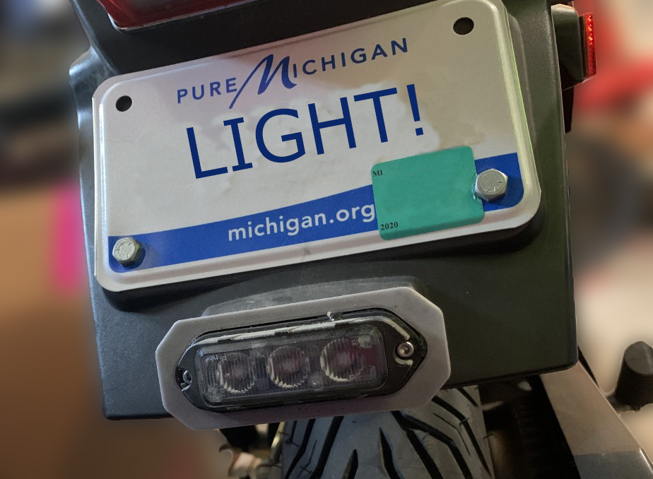 Image of Mini Auxiliary light bracket mounted on a motorcycle
